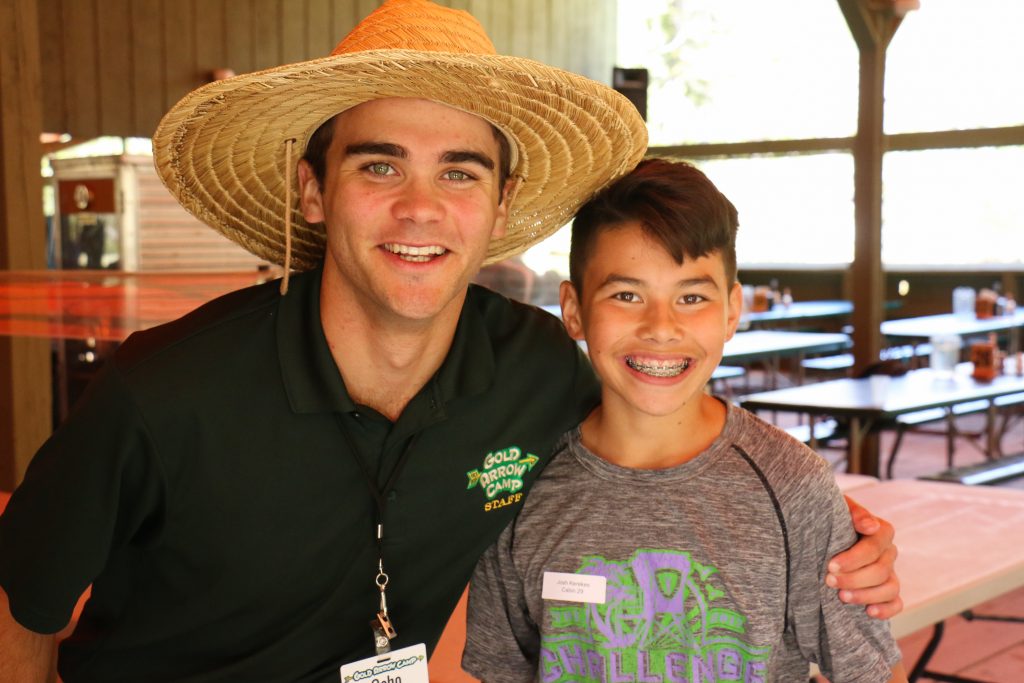 A male camp counselor with his arm around a camper at Gold Arrow Camp